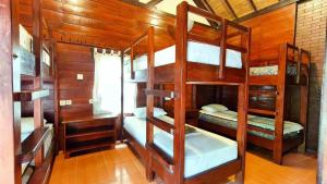 a room with four bunk beds in a house at Gili Buana Hostel & Backpackers Gili Air in Gili Islands