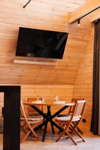 a dining room with a table and a tv on a wall at Давидів Хутір in Zhytomyr