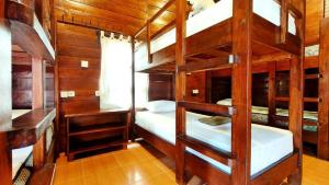 a room with three bunk beds in a cabin at Gili Buana Hostel & Backpackers Gili Air in Gili Islands