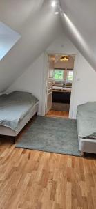 a attic room with two beds and a hallway at Stora Beddinge - Moon apartment in Klagstorp