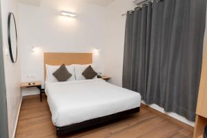 a bedroom with a white bed and a window at Magnum Resorts Candolim in Candolim