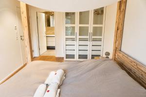a large bed in a room with windows at Swiss Horizon - Mythenblick - Modern 100m2 mit Alpenblick und Terrassen in Hinwil +19 photos