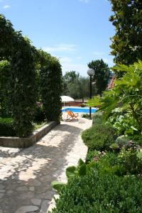 a garden with a bench and a swimming pool at Apartments Petricic with swimming pool in Ičići