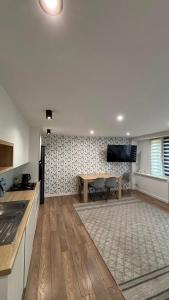 a kitchen and living room with a table and a tv at Apartment Tarasy centrum in Siemiatycze