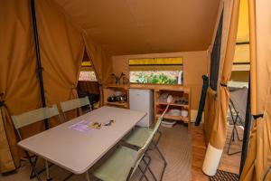 a tent with a table and chairs in it at Camping Onlycamp Les Peupliers in Lepin-le-Lac