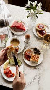 Eine Person isst an einem Tisch mit Tellern voller Essen. in der Unterkunft Art Hotel Pallas by Tartuhotels in Tartu