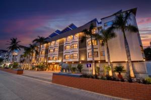 a large building with palm trees in front of it at Hotel Bhagyalaxmi in Shirdi
