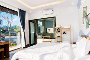a bedroom with a white bed and a large window at Home Mộc Mer Mộc Châu in Mộc Châu