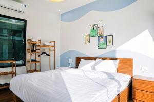 a bedroom with a large bed with white sheets at Home Mộc Mer Mộc Châu in Mộc Châu
