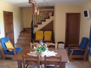 comedor con mesa y sillas azules en Casa Rural Del Antiguo Hojalatero en Ibdes