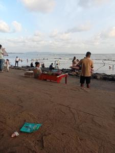 a group of people standing on a beach at Grantley -Beach hotel Alibag in Alībāg