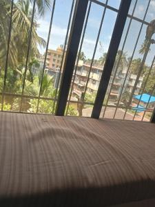a bed in a room with a view of a beach at Grantley -Beach hotel Alibag in Alībāg