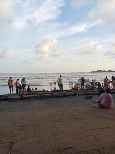 a group of people standing on a beach at Grantley -Beach hotel Alibag in Alībāg