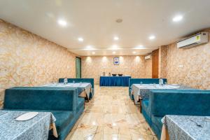 a dining room with blue tables and chairs at Treebo Ten Eleven Grand, Scheme 78 in Indore