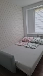 a bedroom with a white bed and a window at Apartment Tarasy centrum in Siemiatycze