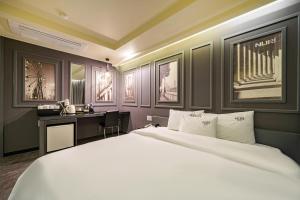 a bedroom with a large white bed and a desk at Busan Gwangalli Nuri Hotel in Busan