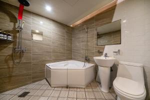 a bathroom with a toilet and a tub and a sink at Busan Gwangalli Nuri Hotel in Busan +63 photos