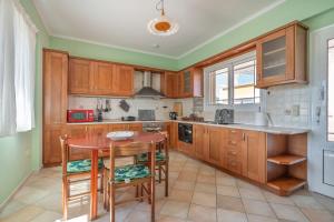 a kitchen with wooden cabinets and a wooden table at Agis Luxury House in Lefkada
