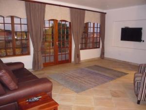 a living room with a couch and a tv at Avocado Grove Guest House in White River