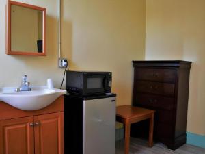 a bathroom with a sink and a tv on a counter at Desmond Hotel in San Francisco