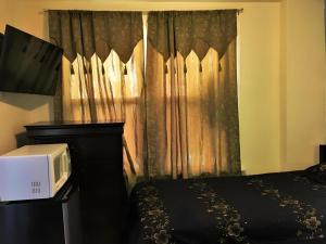 a bedroom with a bed with a microwave and a window at Desmond Hotel in San Francisco
