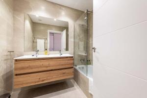 a bathroom with a sink and a tub and a mirror at Serena Golf Apartments in Los Alcázares