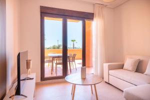 a living room with a couch and a tv and a table at Serena Golf Apartments in Los Alcázares