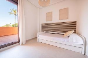 a white bedroom with a bed and a large window at Serena Golf Apartments in Los Alcázares +37 photos
