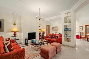a living room with red couches and a tv at Rocha's House - Setúbal in Setubal