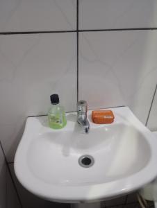 a bathroom sink with a bottle of soap on it at Casa no centro - perto de tudo in Itaguaí +23 photos