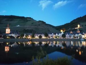 a town on the shore of a lake at night at Moselfrische in Zell an der Mosel