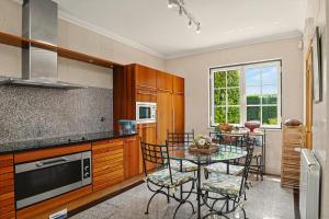 a kitchen with a table and a dining room at Rocha's House - Setúbal in Setubal