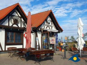 a building with tables and chairs in front of it at Bernsteinquartier Whg 11 "Inselglück" in Kölpinsee