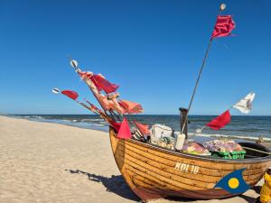 a wooden boat sitting on a sandy beach at Bernsteinquartier Whg 11 "Inselglück" in Kölpinsee