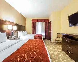 a hotel room with two beds and a flat screen tv at Comfort Suites in Rome +100 photos