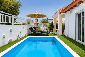 a backyard pool with a slide and an umbrella at Beach House Cavo Kiotari in Gennadi