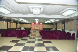 a conference room with red chairs and a stage at Hotel 4G in Bhopal