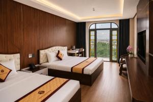 a hotel room with two beds and a window at Thảo Ngân Pleiku Hotel in Pleiku