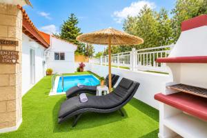 a backyard with a pool and chairs and an umbrella at Beach House Cavo Kiotari in Gennadi