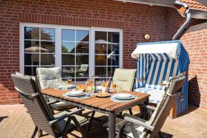 a wooden table and chairs on a patio at FroschKönig in Norden