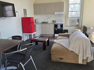 a living room with a couch and a red refrigerator at Courthouse Hotel Gunnedah in Gunnedah