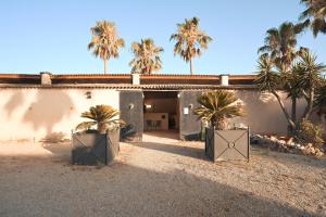two palm trees in front of a building at Finca Caballo Blanco in Montuiri