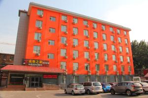 an orange building with cars parked in front of it at Golden Inns Beijing South Railway金泰之家北京南站店 in Beijing