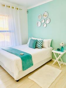 a bedroom with a large bed with blue walls at The Cherry Apartment Nahoon Valley in East London