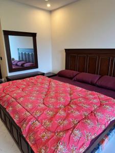 a bedroom with a large bed and a mirror at Swiss Suits, Suit 407 in Taiwāl