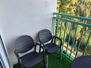 two chairs sitting on top of a balcony at Swiss Suits, Suit 407 in Taiwāl +2 photos