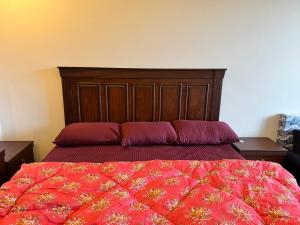 a bedroom with a large bed with a wooden headboard at Swiss Suits, Suit 407 in Taiwāl
