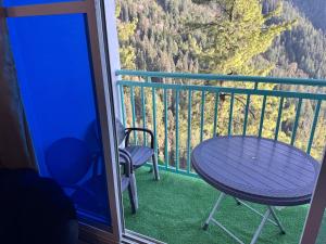 a table and chairs on a balcony with a view at Swiss Suits, Suit 407 in Taiwāl