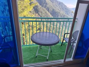 a table and chairs on a balcony with a view at Swiss Suits, Suit 407 in Taiwāl
