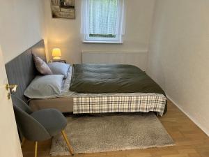 a small bedroom with a bed and a chair at FLC Rooms in Rødby